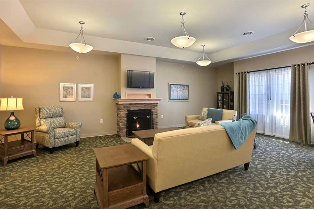 Community room with large windows and cozy seating at Milestone Senior Living Stoughton in Stoughton, Wisconsin.
