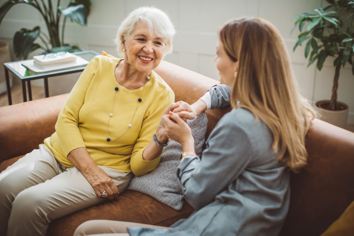 Resident and family member talking while sitting on the couch at Oxford Vista Wichita in Wichita, Kansas