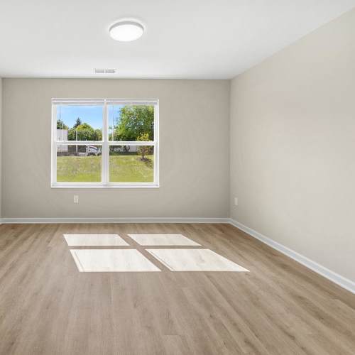 Well-lit living area with lvt flooring at Deville Manor in Oswego, Illinois