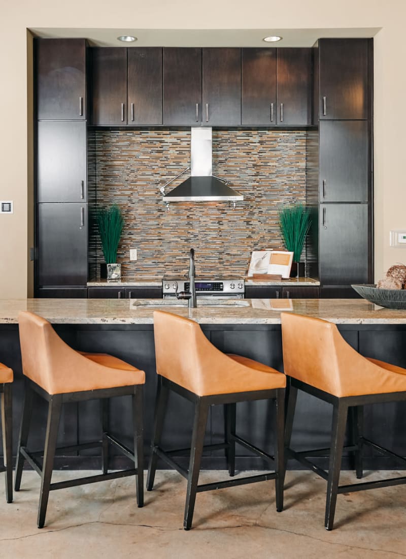 Communal kitchen with bar seating at Marquis Cross Mountain in San Antonio, Texas