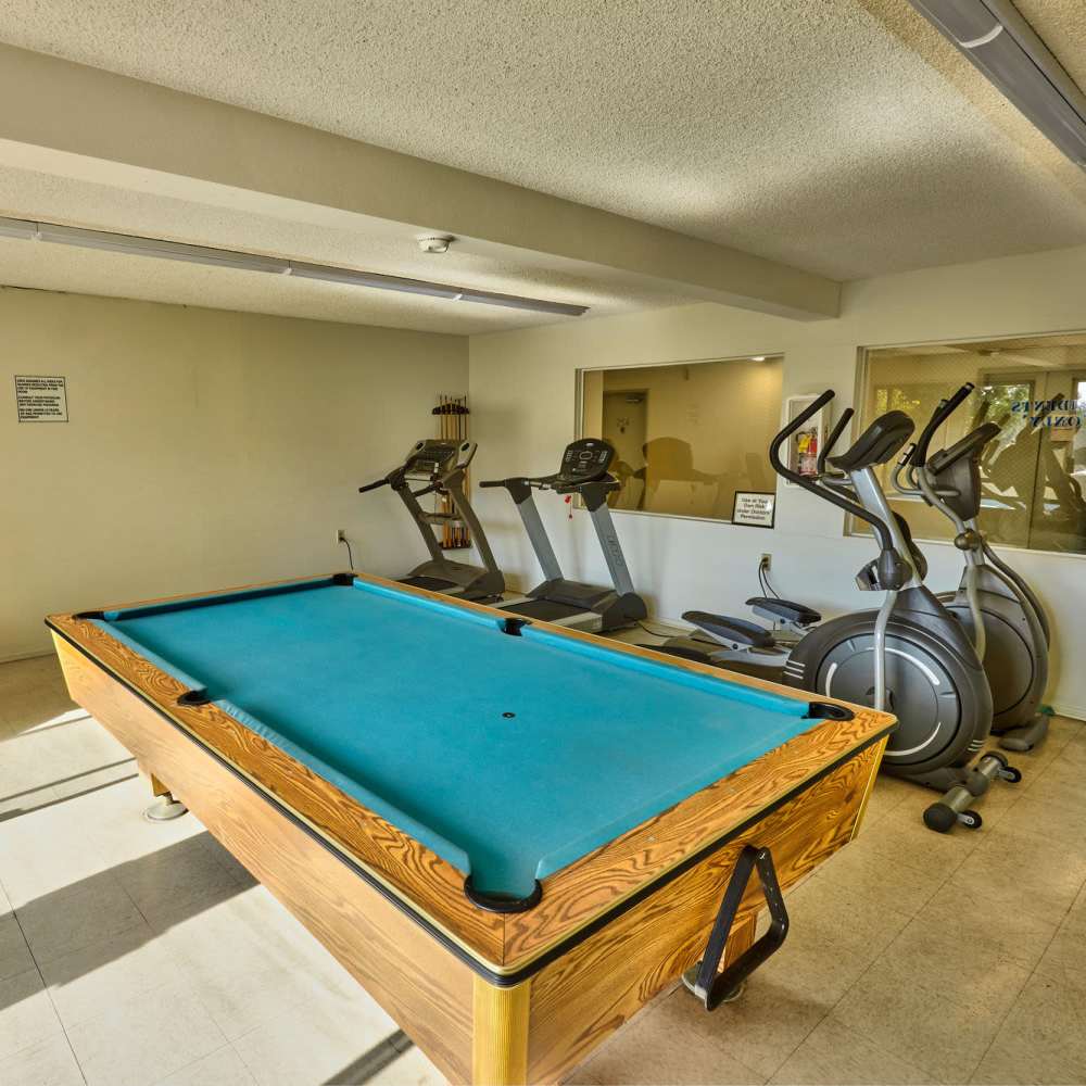 Fitness center with pool table at Acacia Villa in Garden Grove, California, 