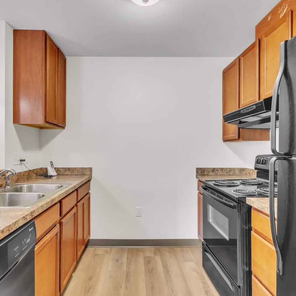 Apartment kitchen with black appliances at Residences on Main in Twin Lakes, Wisconsin