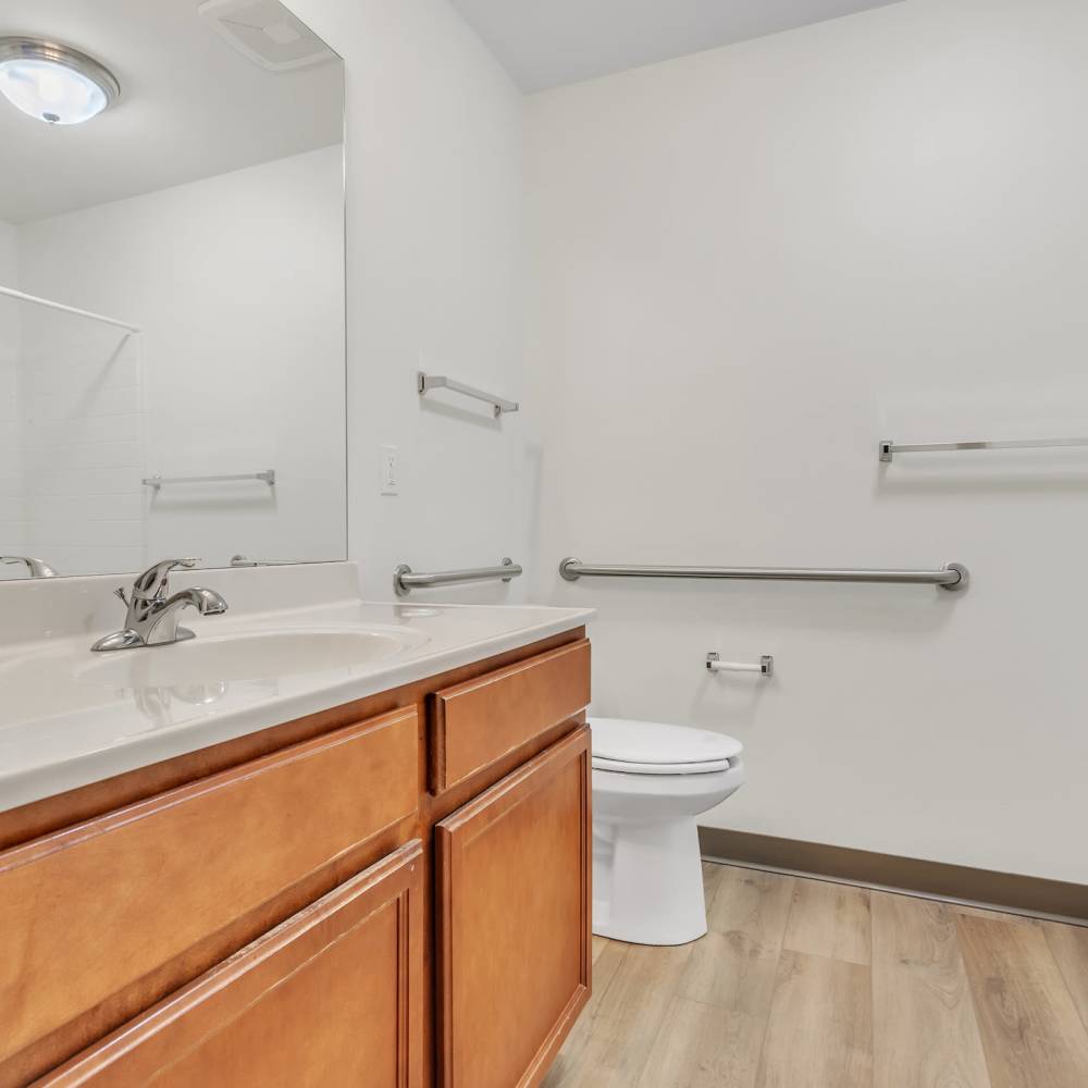Bathroom with vanity, commode and walk-in shower at Residences on Main in Twin Lakes, Wisconsin