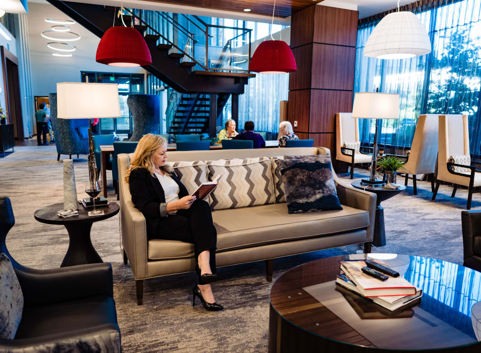 Resident on couch in community area at Murano in Seattle, Washington