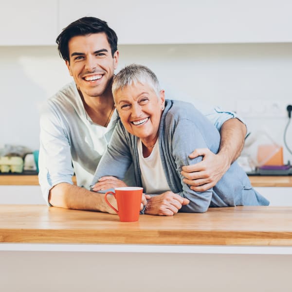 Resident hugging their son at a Quail Park Memory Care Residences of West Seattle community