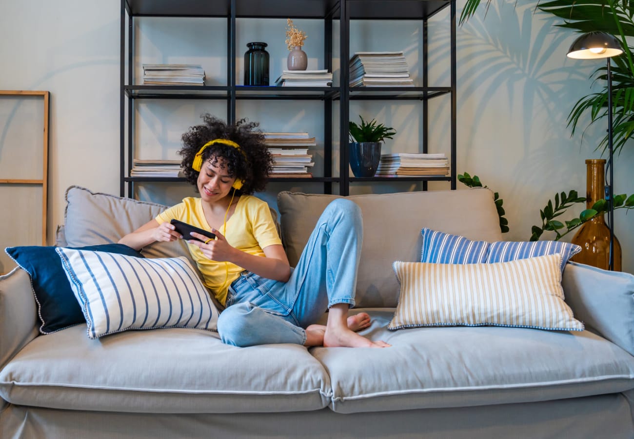 Residents talking and laughing on sofa in their apartment at Apartments at Sanatoga Greene, Sanatoga, Pennsylvania