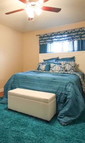 Model bedroom with wood-style flooring and a ceiling fan at Buffalo Ridge in Princeton, Texas