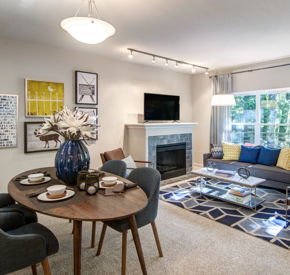 Open-concept living area with plush carpeting and a fireplace in a model home at Sofi at Forest Heights in Portland, Oregon