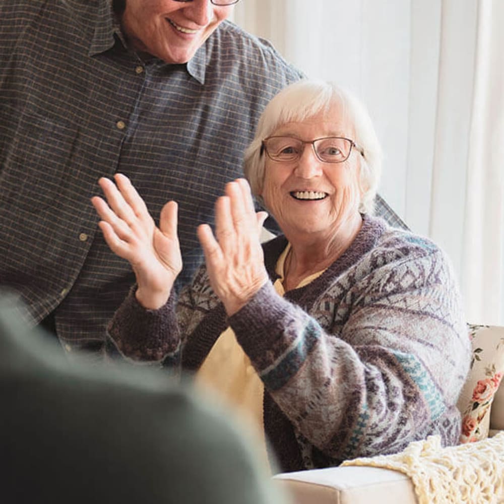 Resident laughing and clapping at Anthology of Clayton View in Saint Louis, Missouri
