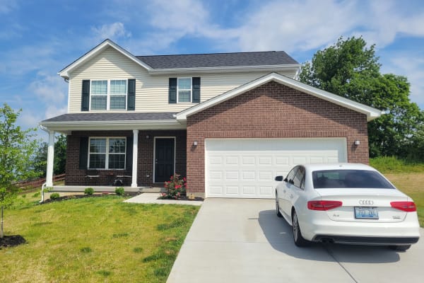 Two-story home with a white car in the driveway