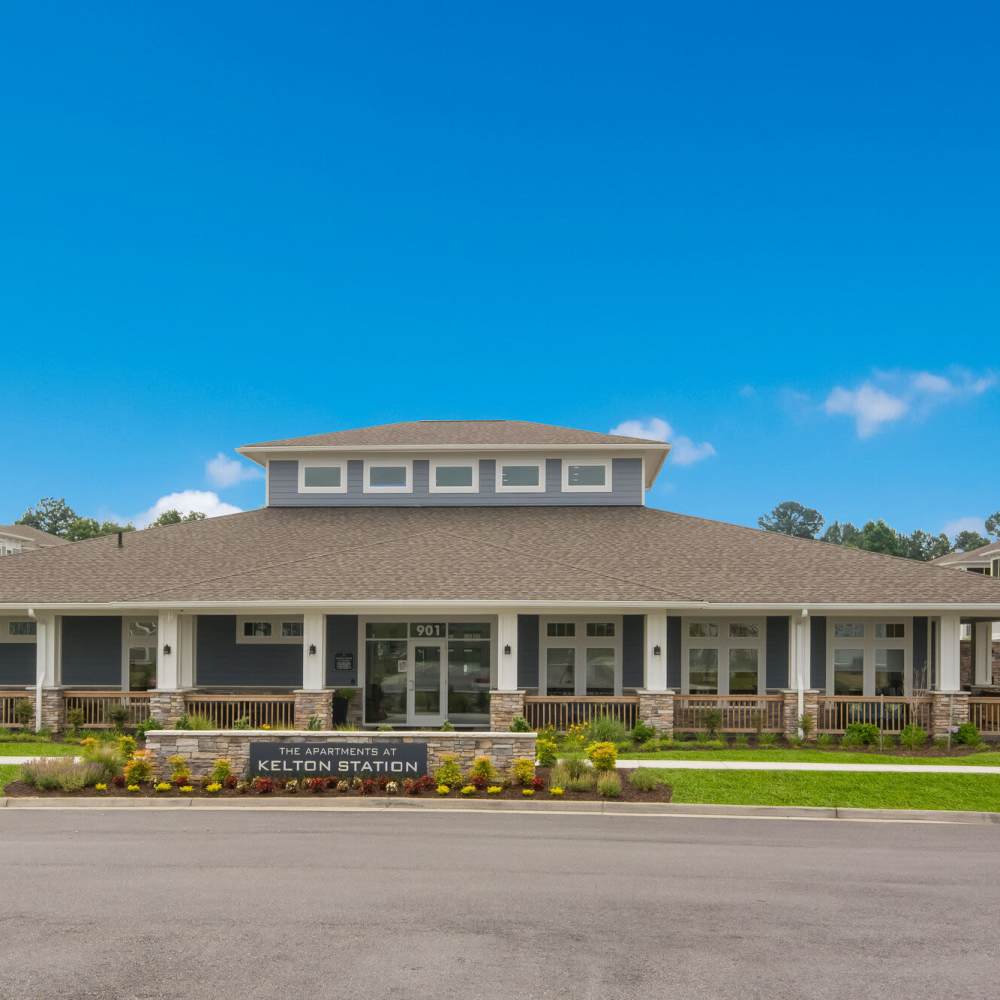 Community entrance with welcoming landscaping at The Apartments At Kelton Station in Williamsburg, Virginia