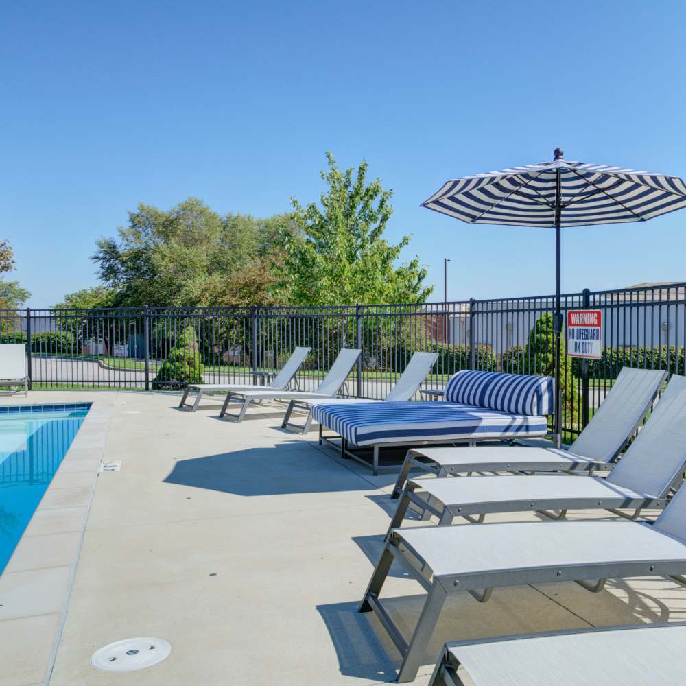 Swimming pool with lounge chair, and canope seating area at Chapel Ridge in Lees Summit, Missouri