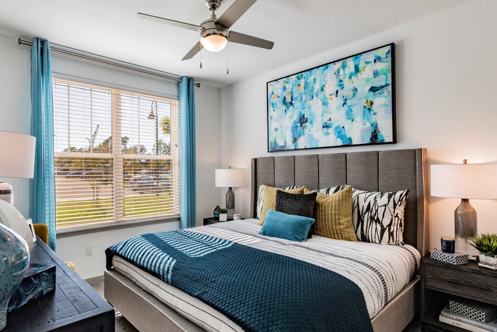 Spacious apartment bedroom with large bed and multiple art prints on the wall at Vue on Lake Monroe in Sanford, Florida