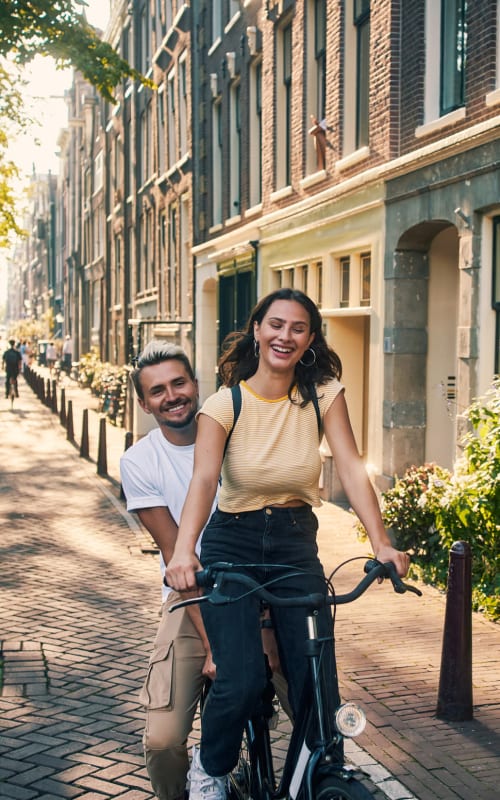 Couple riding tandem on a bike around the neighborhood near Mayfair Reserve in Wauwatosa, Wisconsin