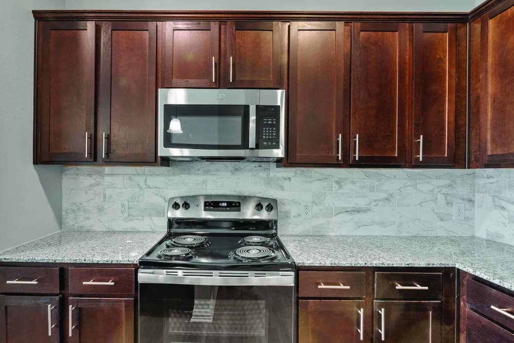 Kitchen with wooden cabinets and microwave at Stonebridge Apartment Homes in Lufkin,Texas