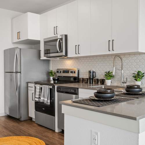 Well-furnished model home's kitchen with stainless-steel appliances at The Plaza Taos in Chandler, Arizona