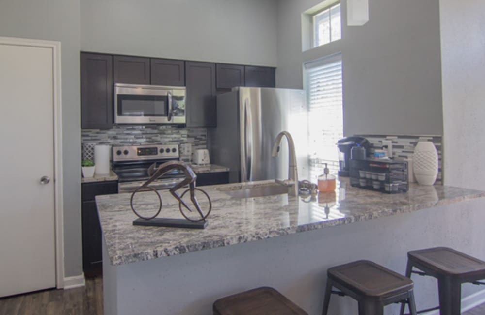 Fully equipped kitchen with a breakfast bar at Century Lake Apartments in Cincinnati, Ohio