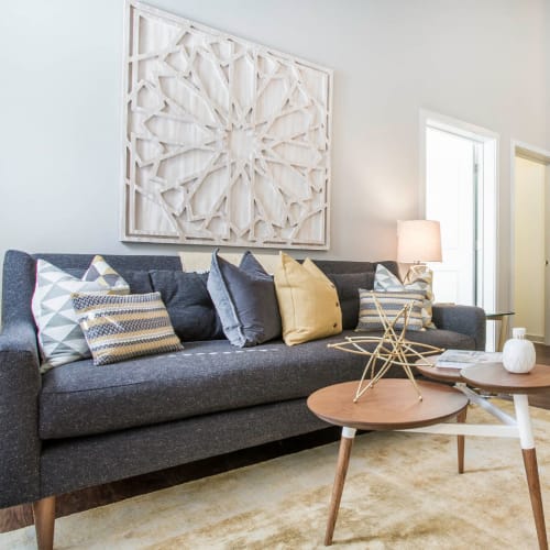 Full size couch with coffee table in living room with rug on wood flooring at Marq Midtown 205 in Charlotte, North Carolina