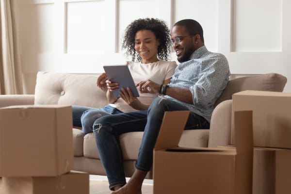 A couple looking for a moving truck online while packing to move boxes to I-205 Mini Storage in Vancouver, Washington