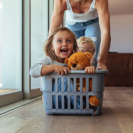 A mother plays and pushes her kids in a clothes hamper at LaCabreah in Brownsburg, Indiana