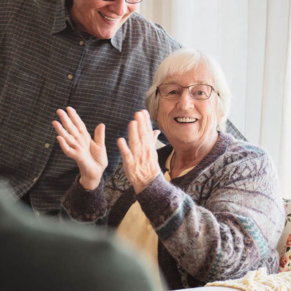 Resident laughing and clapping at Anthology of Wildwood in Wildwood, Missouri
