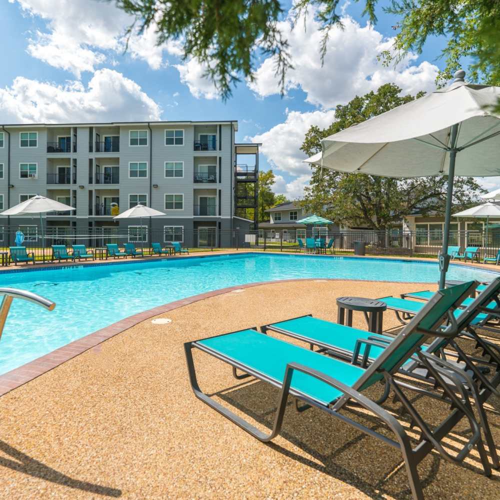 Lounge chairs beside the sparkling pool at Regency Gardens in Bryan, Texas