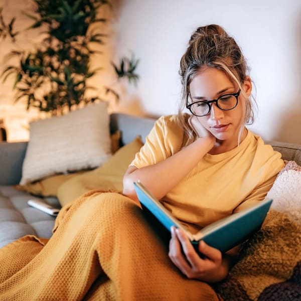 Resident reading a book in their comfortable living room at The Mallory in Raleigh, North Carolina