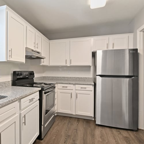 Bright white cabinetry and stainless-steel appliances in a model apartment's kitchen at Crest at Riverside in Roswell, Georgia