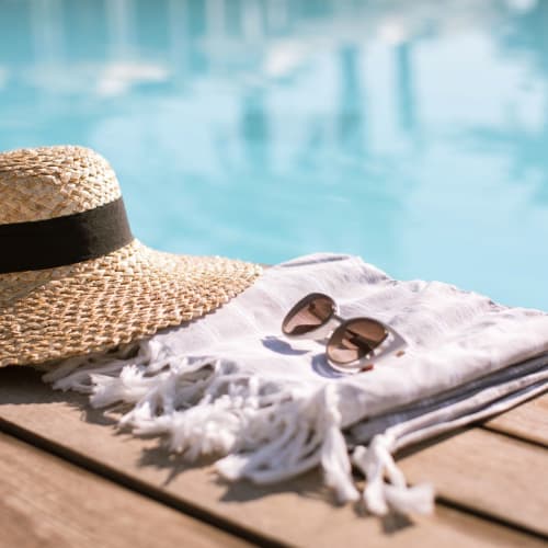 Sun hat, towel and sunglasses near pool at West 38 in Wheat Ridge, Colorado