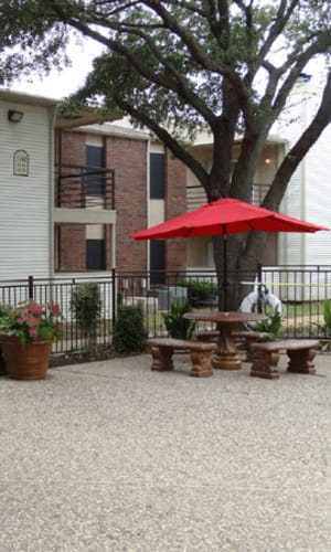 Building exterior and poolside patio table at Willow Glen in Fort Worth, Texas