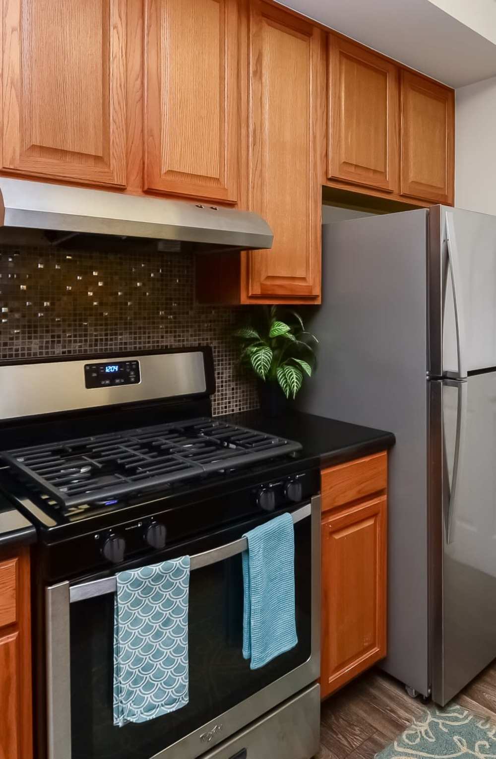 Kitchen with oak cabinets, stainless appliances, and black quartz counters at Bishop