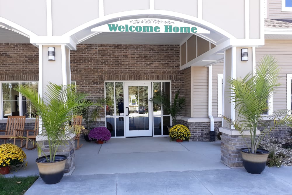 Front entrance accented with potted plants and greenery at Country Meadow Place in Mason City, Iowa