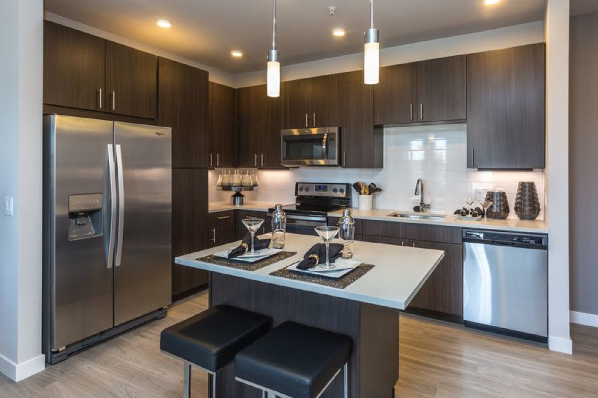 Modern kitchen with stainless appliances and dark wood cabinetry at Strata Apartments in Denver, Colorado