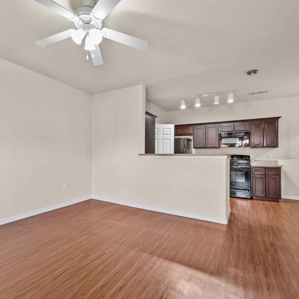 Wood-style floored living room with ceiling fan at Las Torres Apartments in El Paso, Texas