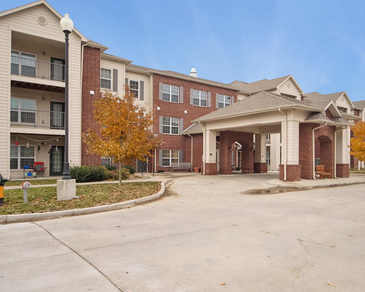 Charming brick apartments with welcoming entrance and seasonal foliage at Villas At Meadow Springs in Ankeny, Iowa 