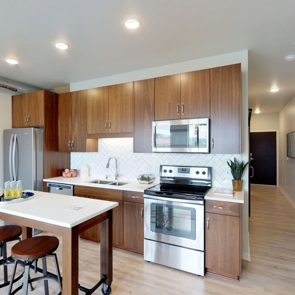 Stainless-steel appliances and custom wood cabinetry in a model home's kitchen at Oaks Union Depot in St Paul, Minnesota