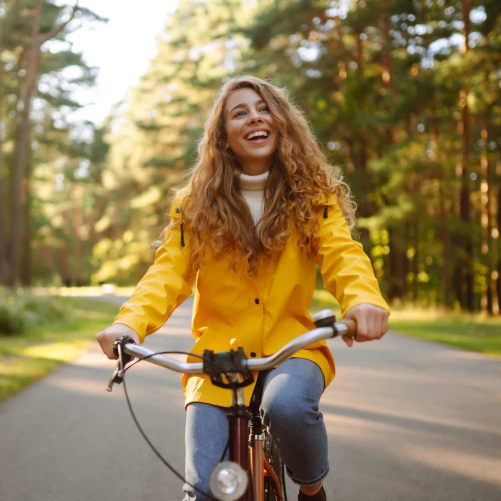 Resident in yellow jacket riding a bicycle at Atrium Gardens in Arlington, Texas