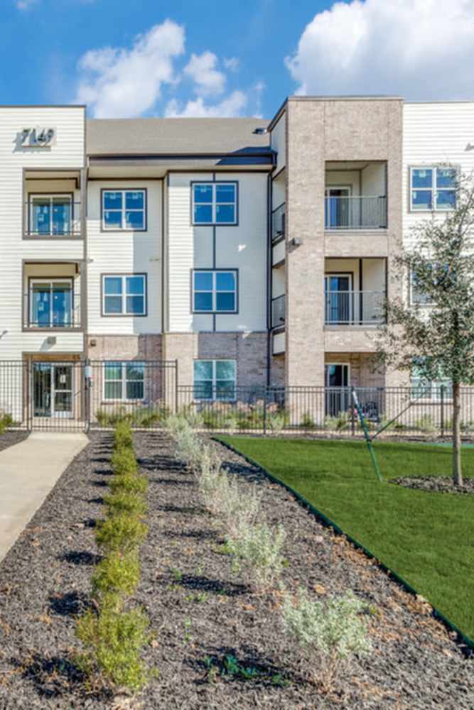 Exterior of building with well maintained lawn at The Trail Lakes in Fort Worth, Texas