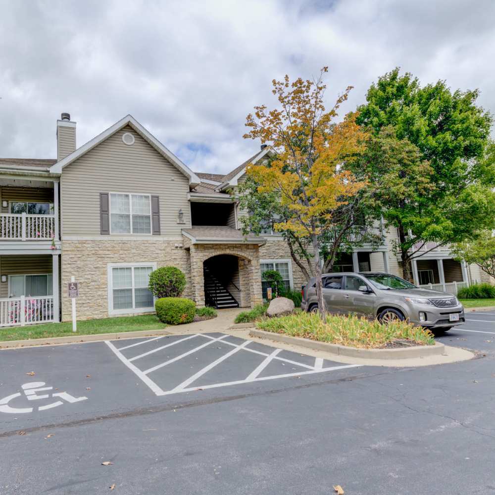 Charming apartment entrance with lush landscaping and convenient parking at Boulder Springs in Maryland Heights, Missouri.