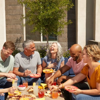 Happy family eating outdoor in bbq area at Las Casas at Windrose in Litchfield Park, Arizona