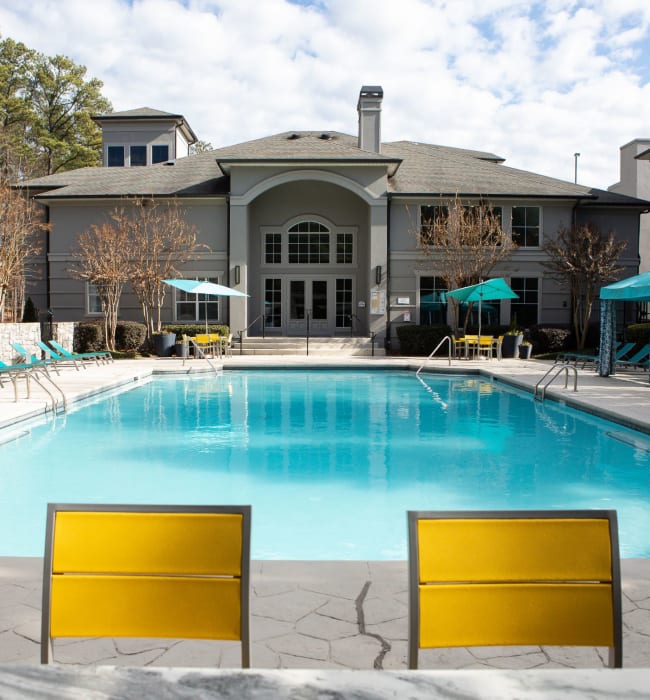 Chairs surrounding the sparkling community pool at Marq Perimeter in Atlanta, Georgia
