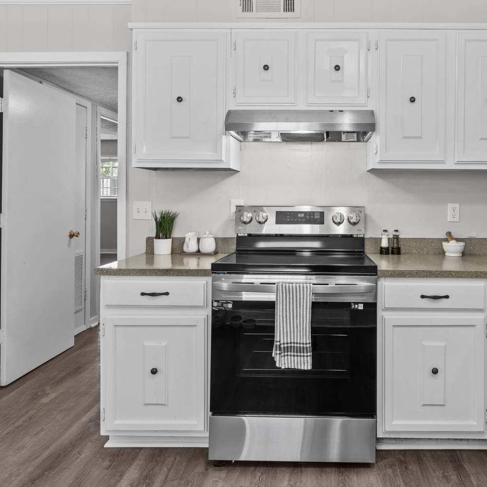 Modern kitchen with sleek stainless steel appliances and charming white cabinetry at Pecan Ridge in Vicksburg, Mississippi.
