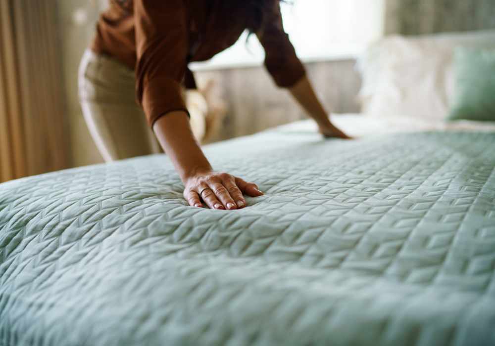 Resident making her bed at Crystal Commons Townhomes in Gates, New York