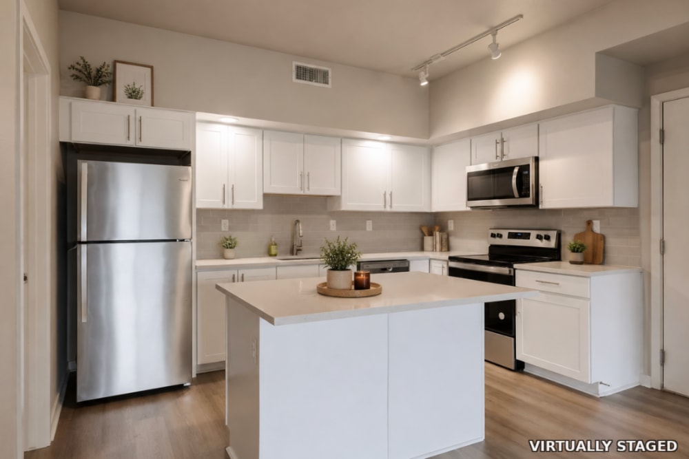 Apartment kitchen with kitchen island at The Greens at Van de Water in Loveland, Colorado  