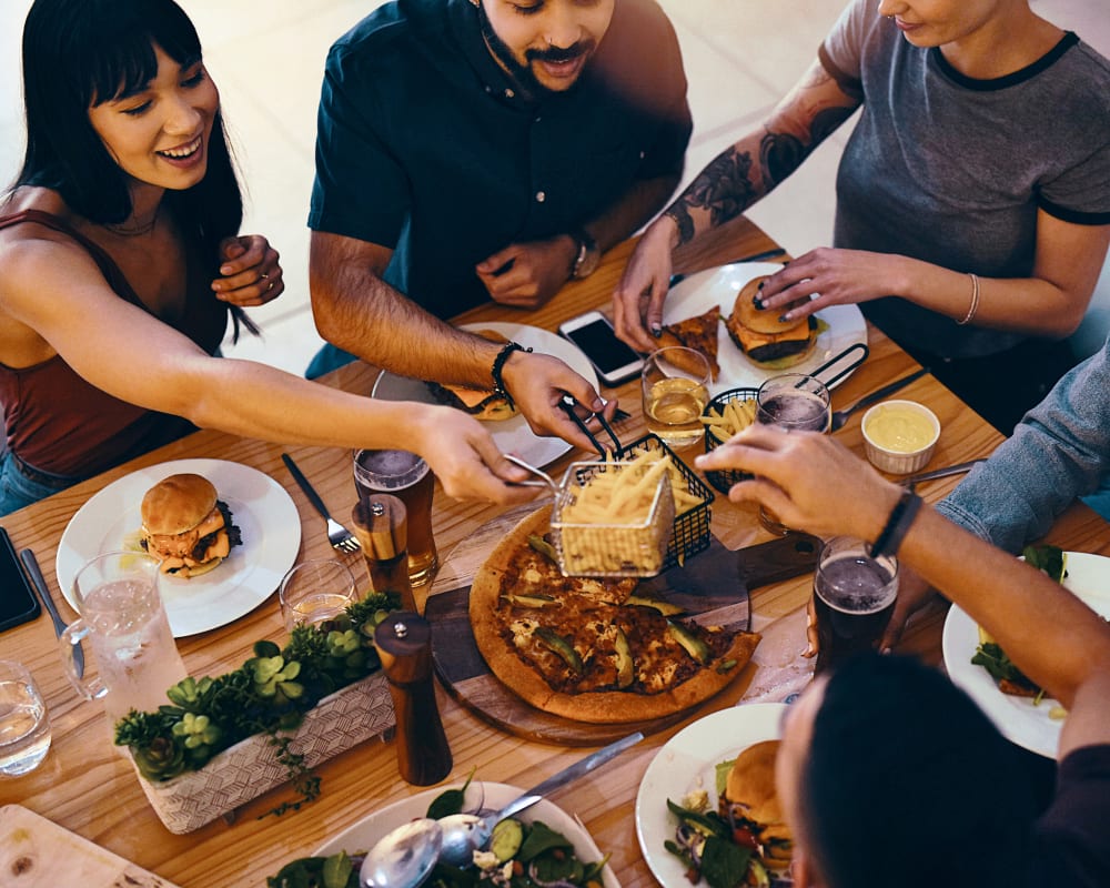 residents enjoying dinner together outside at Greenpointe Apartment Homes in Santa Clara, California