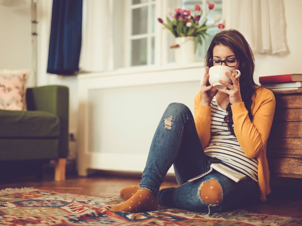 Resident relaxing with a cup of tea in her new home at Sofi at Forest Heights in Portland, Oregon