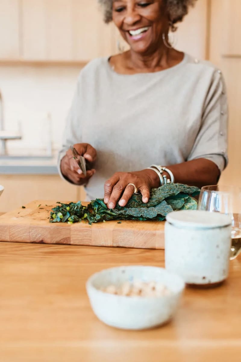 Resident chopping kale at Carriage Inn Conroe in Conroe, Texas