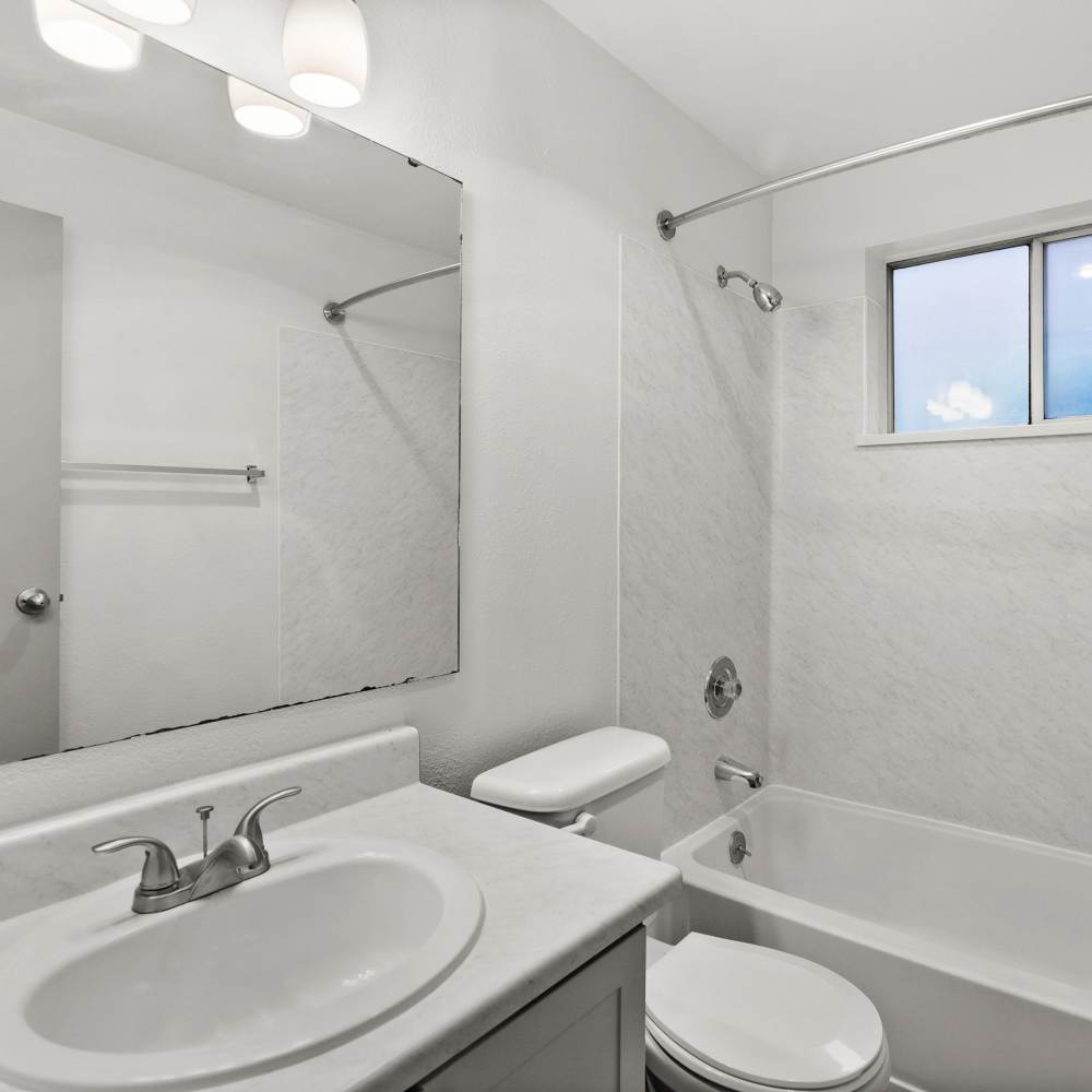 Bathroom with a bathtub and large mirror at Lodge at Madrona Ridge in Tacoma, Washington