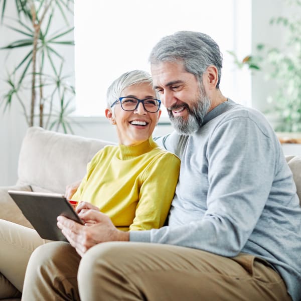 A couple looking at a tablet at Kenmore Senior Living in Kenmore, Washington