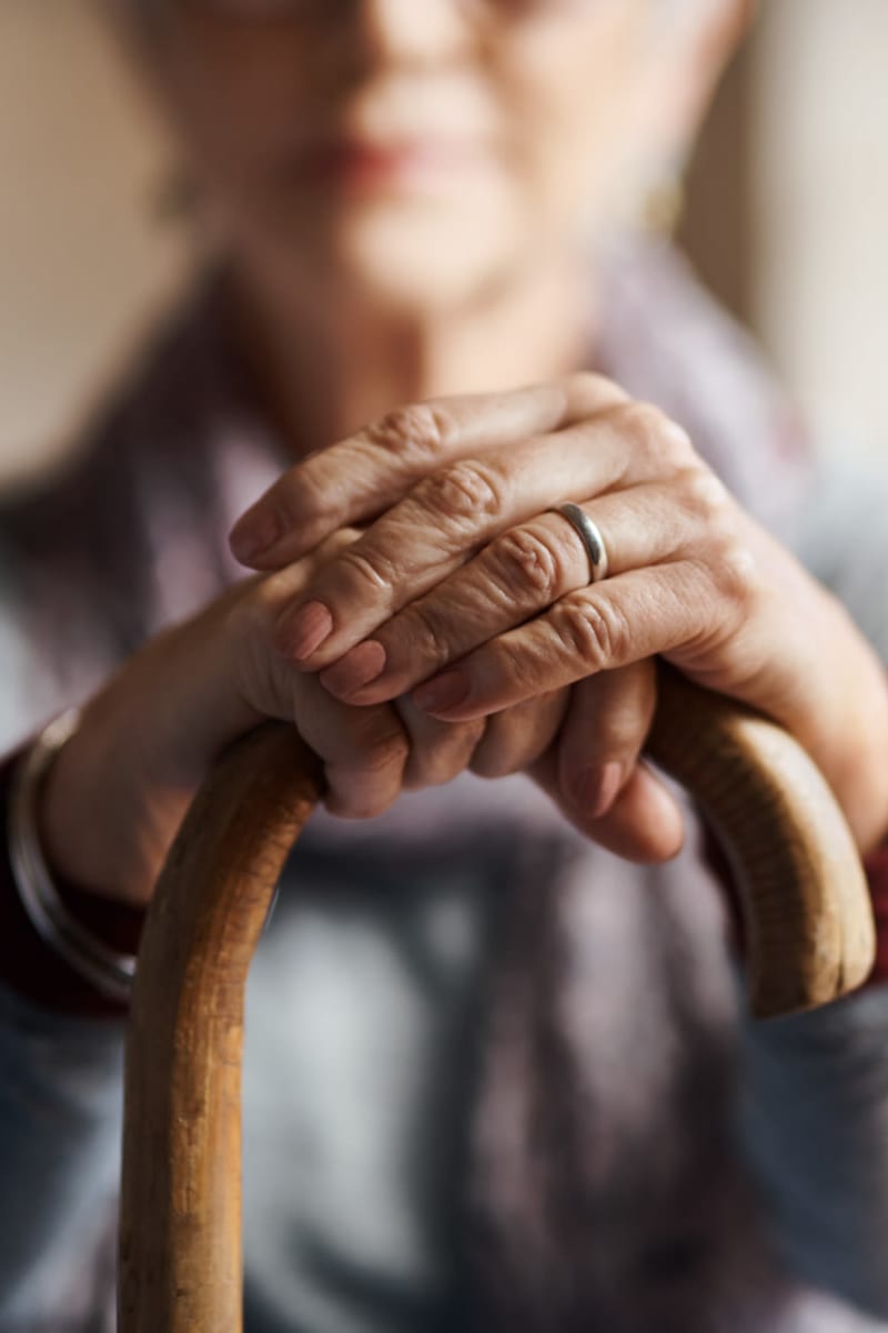 Resident resting on their hands on their cane at Transitions At Home in Elkhorn, Wisconsin